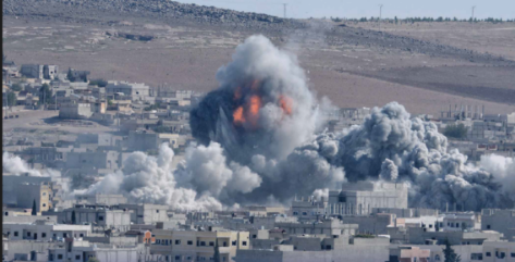 A large, fiery explosion erupts in the middle of a densely populated town, sending a huge cloud of smoke and debris into the air.